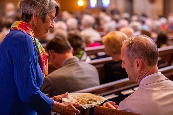 Communion is offered to a worshipper during a service at Bryn Mawr Presbyterian Church